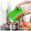 Pack of 2 flexible, non-slip, dishwasher-safe chopping mats used to transfer sliced tomatoes into a cooking pot.