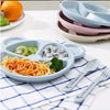 Cartoon bear divided dinner plate set with fork and spoon for toddlers, featuring food on a pastel tray.