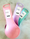 Heat-resistant silicone kitchen spoon rest mat set for spatulas, tongs, and cooking utensils in pastel colors.