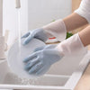 Silicone cleaning gloves with built-in scrubbers for easy dishwashing and kitchen cleaning tasks under running water.