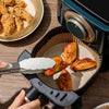 50-piece air fryer disposable paper liners used for cooking crispy chicken wings in a non-stick air fryer basket.