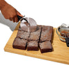 Professional stainless steel pizza cutter wheel slicing brownies on a wooden cutting board, easy clean kitchen gadget.