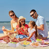 Disposable elastic food storage covers keeping picnic bowls and containers fresh on the beach for a family meal.
