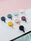 Pack of 12 creative plastic sticky hooks in assorted colors for wall storage, home organization, and hanging decor.