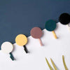 Pack of 12 creative plastic sticky hooks in various colors for wall-mounted home organization and decor.