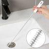 Long, flexible sink drain cleaning brush with white bristles for removing hair and clogs from bathroom sink pipes.