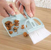 Set of mini hand brush and dustpan cleaning small debris off a desk or tabletop surface.