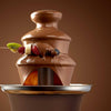3 Tier Mini Chocolate Fountain cascading delicious melted chocolate with fresh fruit skewers for parties and events.