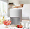Ice Crusher White manual machine with hand crank for making shaved ice and slushies with fresh fruit dessert.