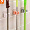 Broom Holder Clips wall-mounted to organize mops and cleaning tools in the home, kitchen, or laundry room.