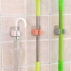 Broom holder clips for wall-mounted storage of mops, brooms, and umbrellas for home organization.