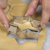 12pcs cookie cutter set cutting star-shaped dough for baking delicious homemade Christmas cookies.