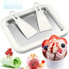 Small household yogurt frying machine for DIY rolled ice cream with two spatulas and fresh fruit toppings.