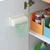 Wall-mounted garbage bag storage box and adhesive kitchen bag dispenser attached to the inside of a cabinet door.