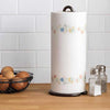 Metal tissue roll stand and heavy-duty vertical paper towel holder on a kitchen counter with eggs and spices.