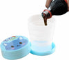 Foldable Magic Glass for Kids: portable collapsible travel cup with cute blue cat lid being filled with a drink.
