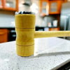 Wooden meat hammer, a double-sided professional meat tenderizer mallet on a kitchen countertop.