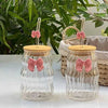 Premium 500ml aesthetic ribbed glass cup with pink bow, bamboo lid, and glass straw for iced coffee or boba tea.