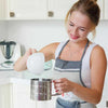 Stainless Steel Flour Sifter Cup – Handheld manual flour filter being used to sift flour in a bright kitchen.
