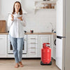 Heavy-duty gas cylinder base with wheels for easy movement, featuring a durable plastic trolley stand in a kitchen.