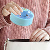 Foldable Magic Glass for Kids, a portable, collapsible travel cup with a cute blue cat lid being packed in a bag.