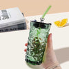 Aesthetic 450ml green glass tumbler with straw and cute silver bear lid, perfect for iced coffee or boba tea.