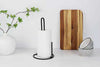 Heavy-duty metal tissue roll stand and vertical paper towel holder in a modern kitchen setting.