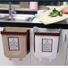 Foldable hanging trash can as a wall-mounted kitchen cabinet waste bin for easy food scrap disposal.