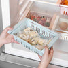 Stretchable fridge organizer basket for adjustable, space-saving kitchen storage in a refrigerator.