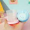 Foldable Magic Glass for Kids: portable collapsible travel cup with bunny lid held in hand for school or travel.