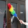 Rainbow Microfiber Duster cleaning a wooden cabinet, used as a static charge dust remover for home and car surfaces.